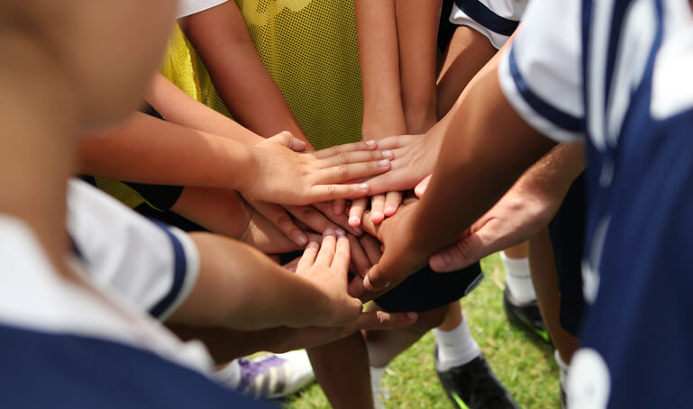 private school students doing a team handshake